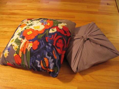 Two pillows are sitting on a wooden floor.