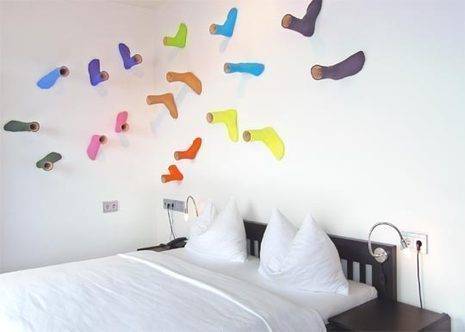 Colorful socks are being used to decorate a white wall.