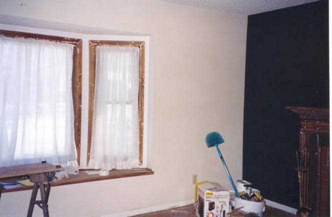 A window in a room has sheer white curtains.