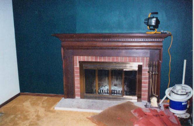A fireplace is on a blue colored wall.
