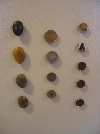 Three rows of marbles and buttons are along a surface.