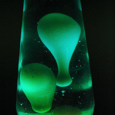 Green blobs come up in a lava lamp.