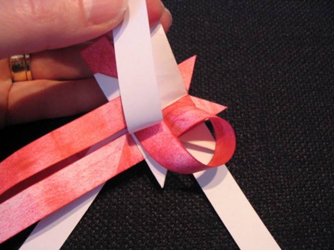 Woman wearing ring and tying pink ribbon.