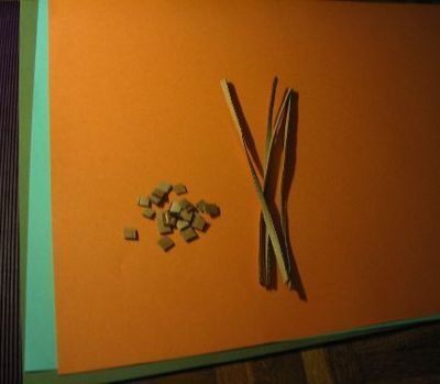 Small pieces and long thin pieces of cardboard pieces and colored papers for craft.