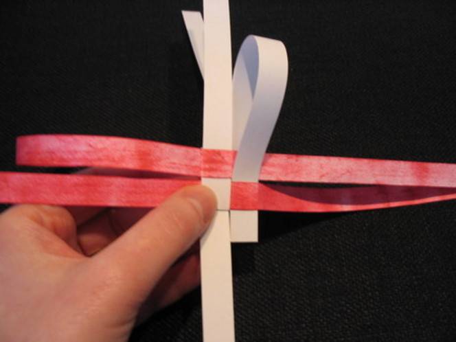 A white and pink paper craft being made