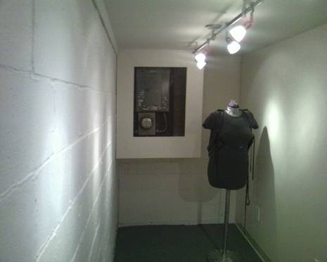 A lit room with a headless mannequin in a shirt