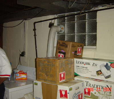 Man standing in a utility room with many boxes stacked up.