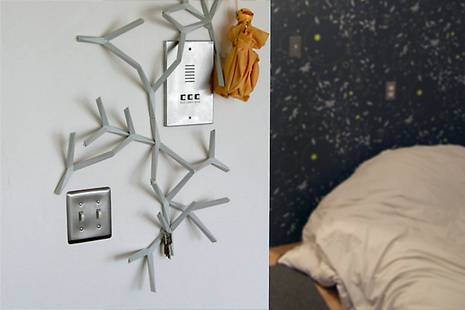 A tree decoration next to an intercom which is next to a pillow in a room.
