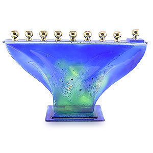 A blue glass menorah with a green pattern.