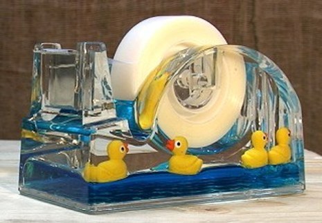 Tape dispenser with a pond scene inside including ducks on fake water.