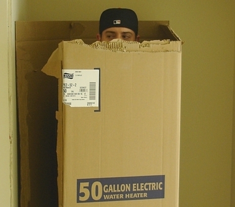 A man behind the water heater cardboard box.