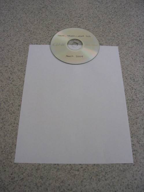 A disk sits on a paper on the floor.