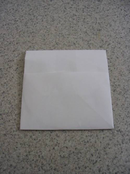 A white square paper envelope lies on a speckled stone counter surface.
