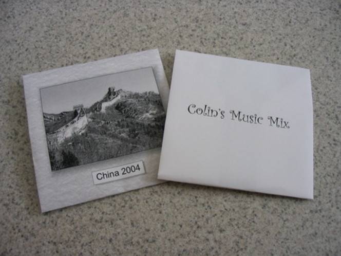 A compact disc case made of folded paper and showing text on one side and an image on the other.