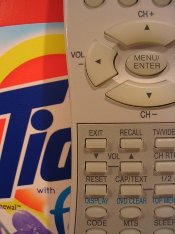 A telephone is sitting near washing detergent.