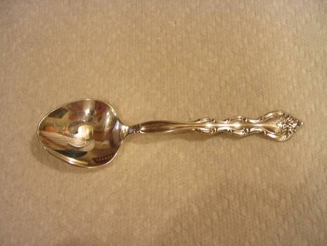 A shiny spoon sits on the floor.