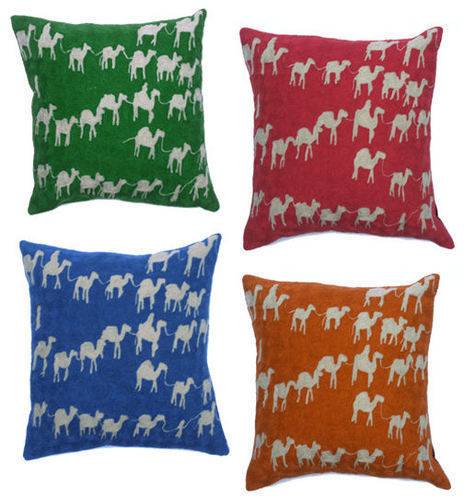 Four pillows with outlines on camels with green, red, blue, or orange background.