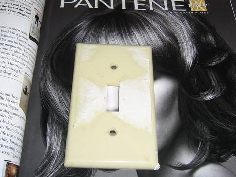A light switch is sitting on a magazine ad.