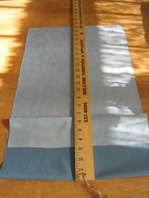 A ruler is on top of blue fabric.