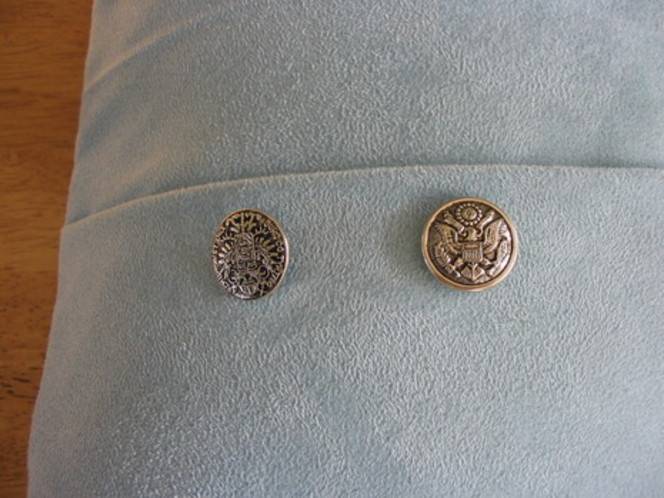 Two buttons are on a light blue fabric.