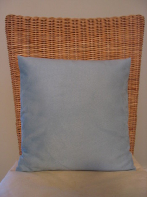 Square pillow on chair with wicker back.