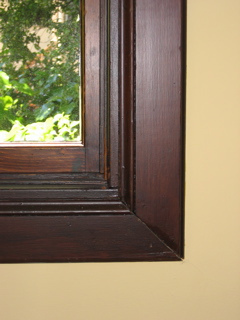 Corner of wood picture frame on wall.