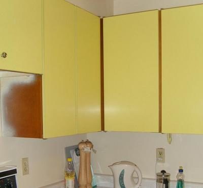 "A Yellow wardrobes with things in a kitchen"
