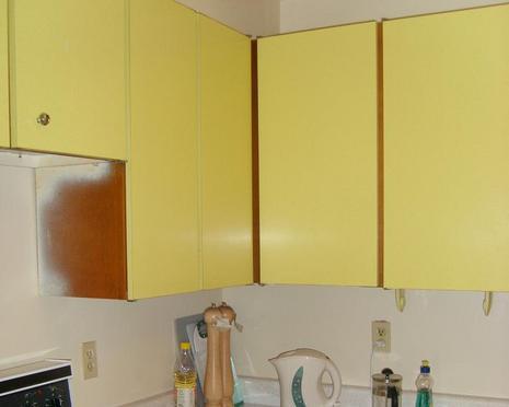 "A Yellow wardrobes with things in a kitchen"