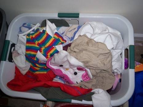 A pile of colorful clothes is in a laundry basket.