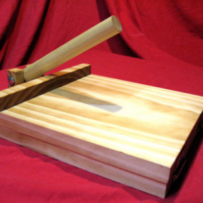 A wooden contraption sits on a red sheet.