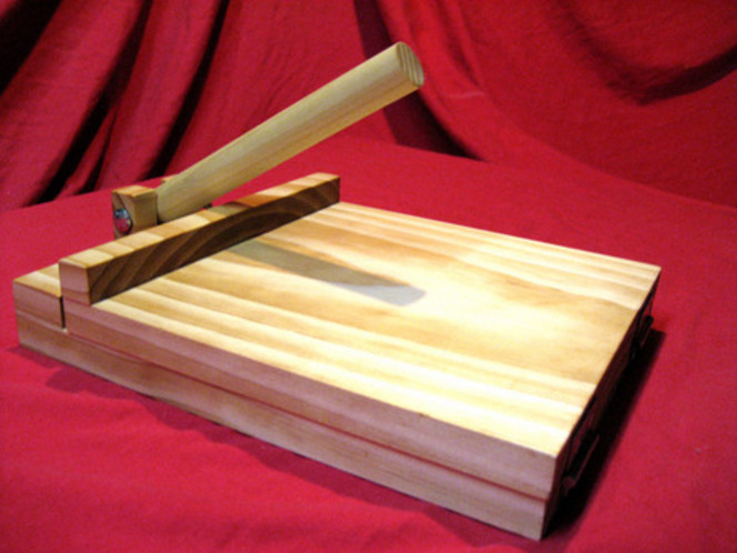 A wooden contraption sits on a red sheet.