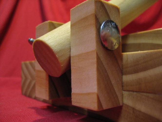 A round piece of wood is bolted to two square pieces of wood to make a tortilla press.