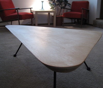 A triangular table with three black legs.