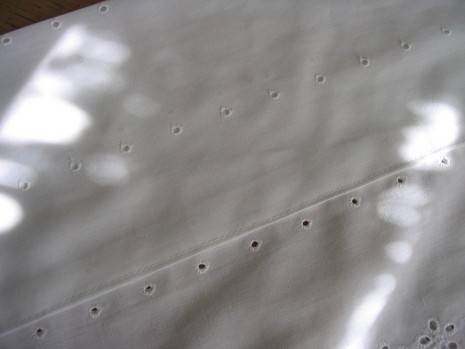 A white piece of material with lines of holes.