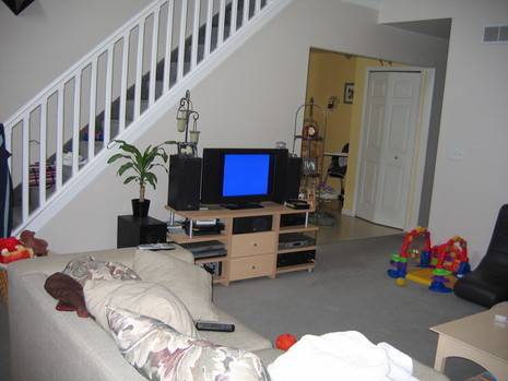A living room has steps, a couch and a TV.