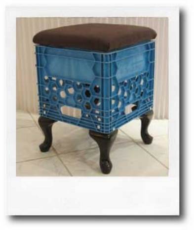 A stool made from a milkcrate with wooden legs and a cushioned seat.