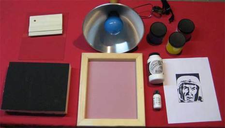 Screen, colors, face printed paper, squeezer are placed in red background for screen printing.
