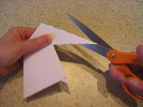 A person is using a pair of scissors to cut a piece of paper.