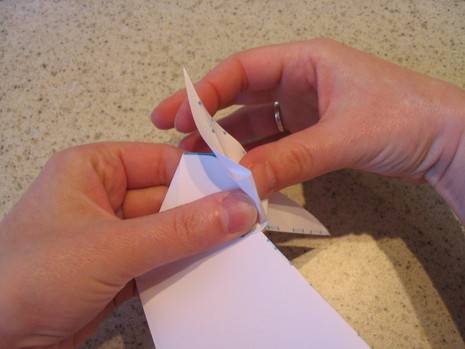 A person folding paper for origami craft.