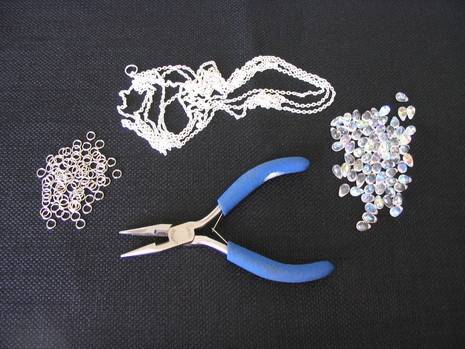 A pair of pliers and jewelry trinkets.