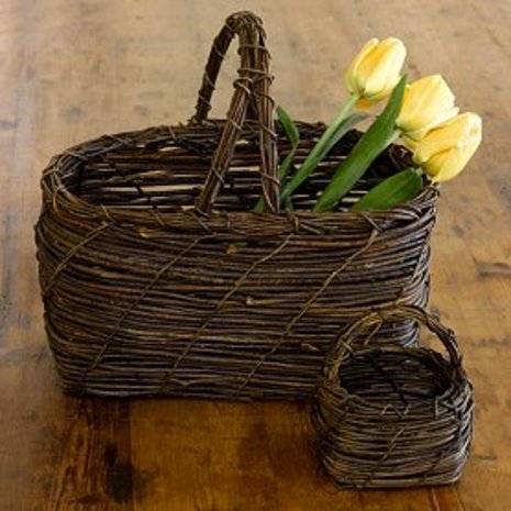 Yellow flowers are in a brown basket.