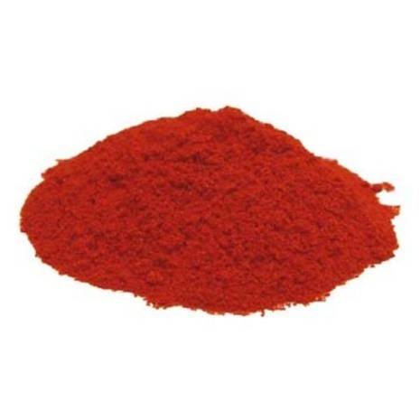 A red mound of powder sits on a white surface.