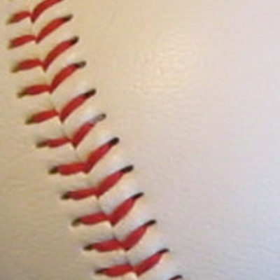 A close-up view of the red stitched seam of a baseball.