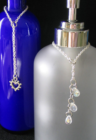 Two bottle necklaces,one blue and one gray, with necklaces over the top of the necks.