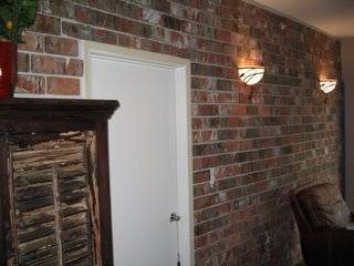 Light sconces hang from a brick wall.
