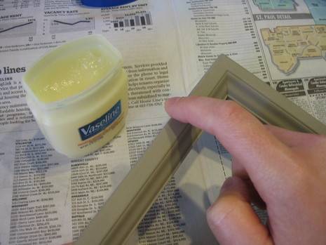 Woman spreading petroleum jelly on a wood picture frame.