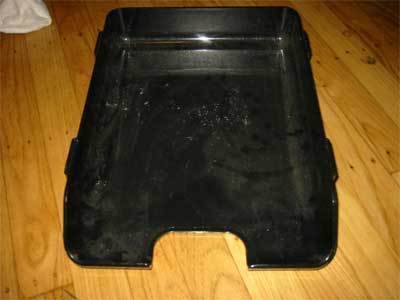 Black pan on a golden brown wood floor.