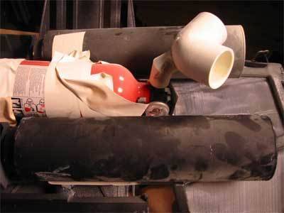 A plastic elbow joint and a small fire extinguisher laying together.