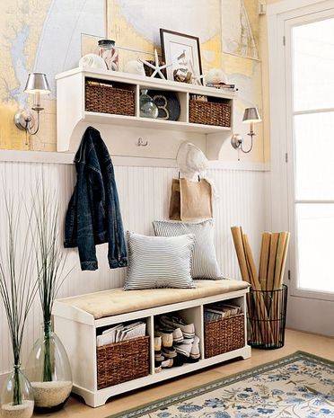 A white bench and shelves in an area near a window are used for organizing.