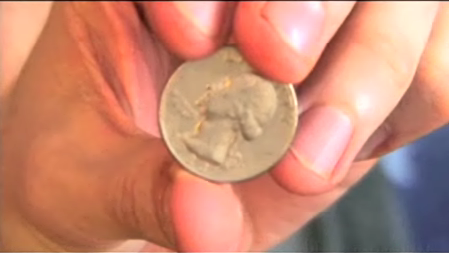 Man showing statue on coin.